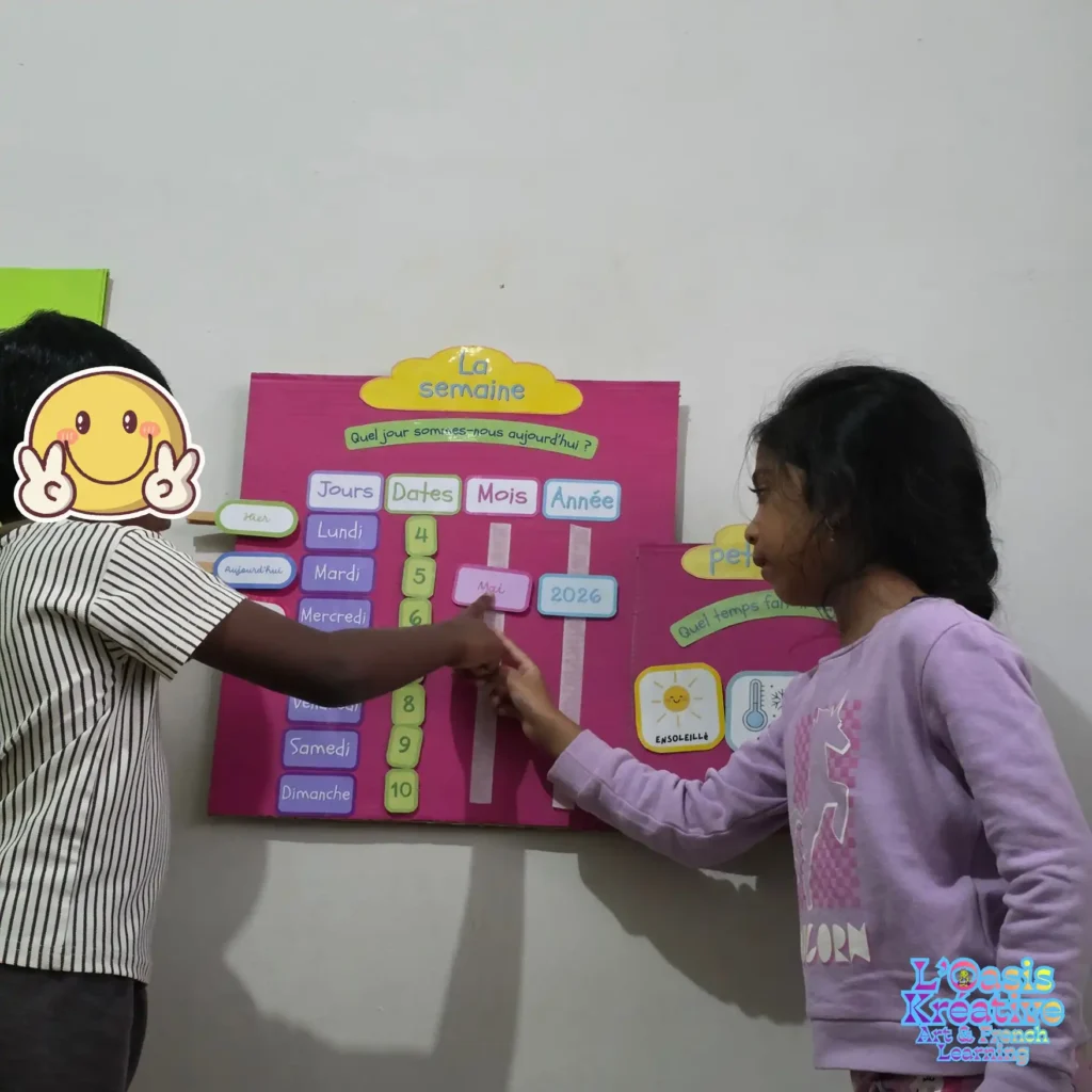 Deux enfants apprennent le français à l'aide d'un calendrier interactif coloré lors d'un atelier Art & French à l'Oasis Kréative.