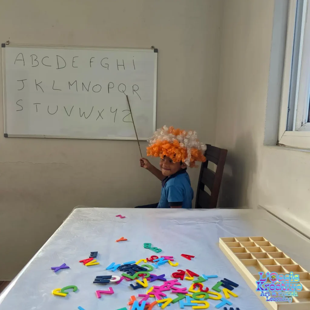 Jeune enfant participant à un atelier d’éveil au français à L’Oasis Kréative, apprenant l’alphabet de façon ludique avec Zazie Jam.