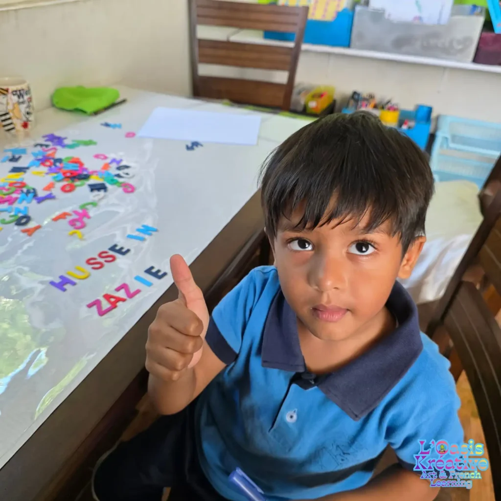 Petit garçon participant à un cours d’éveil au français à L’Oasis Kréative à Curepipe, apprenant les lettres de l’alphabet de façon ludique avec Zazie Jam.